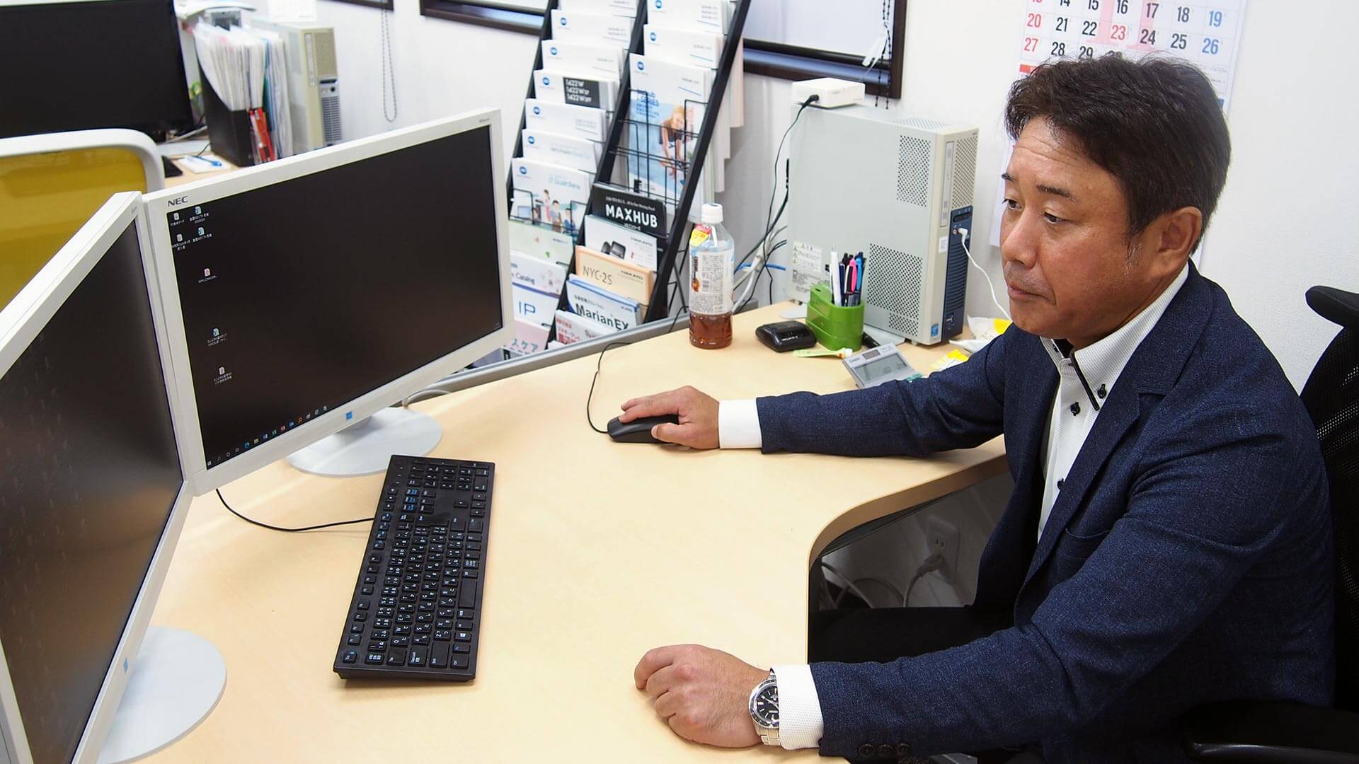 新オフィスのデスクトップで作業する上野社長
